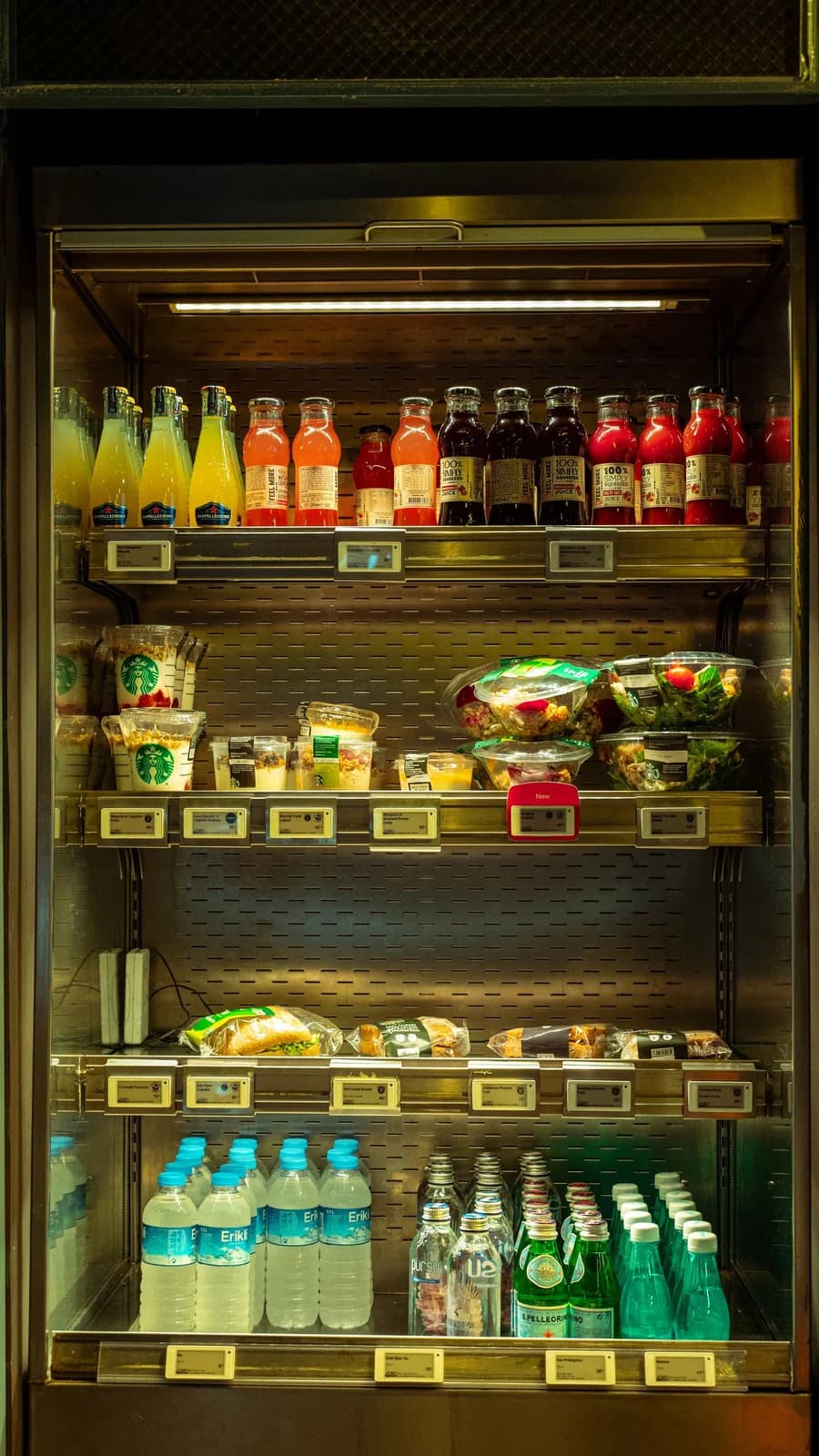 Illuminated display chiller stocked with drinks and fresh food