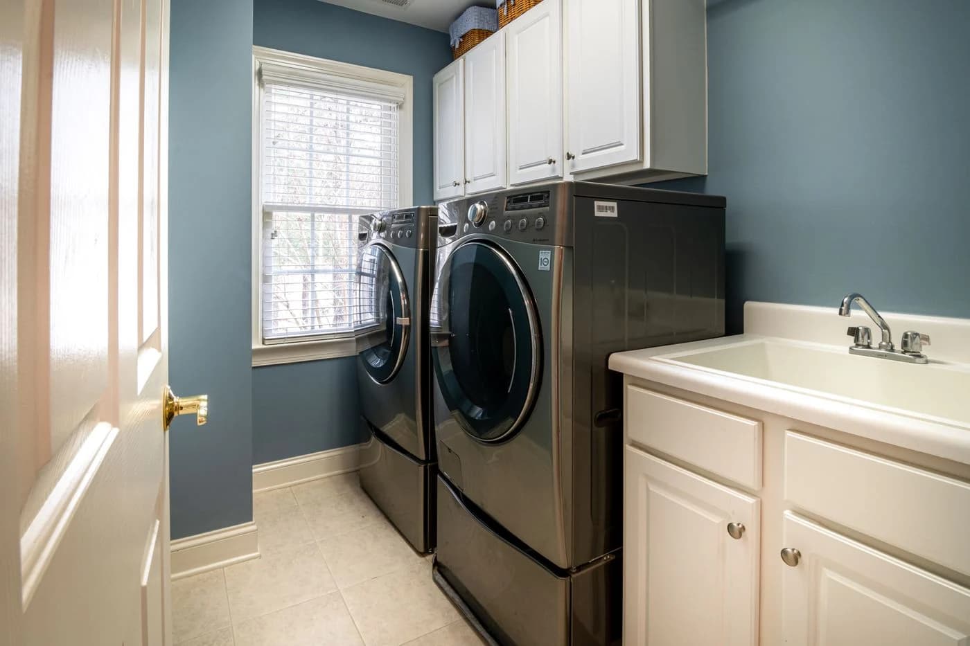 Front-load washing machines in a bright fitted laundry room